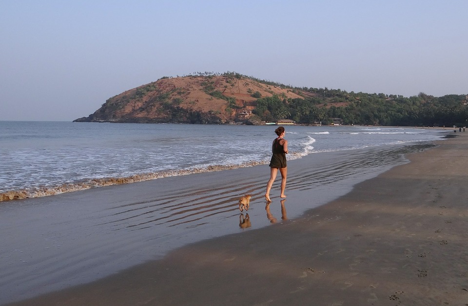 Mergina bėga su šunimi. Galite bėgti su savo šunimi bet kokiomis sąlygomis, net paplūdimyje, prie jūros.